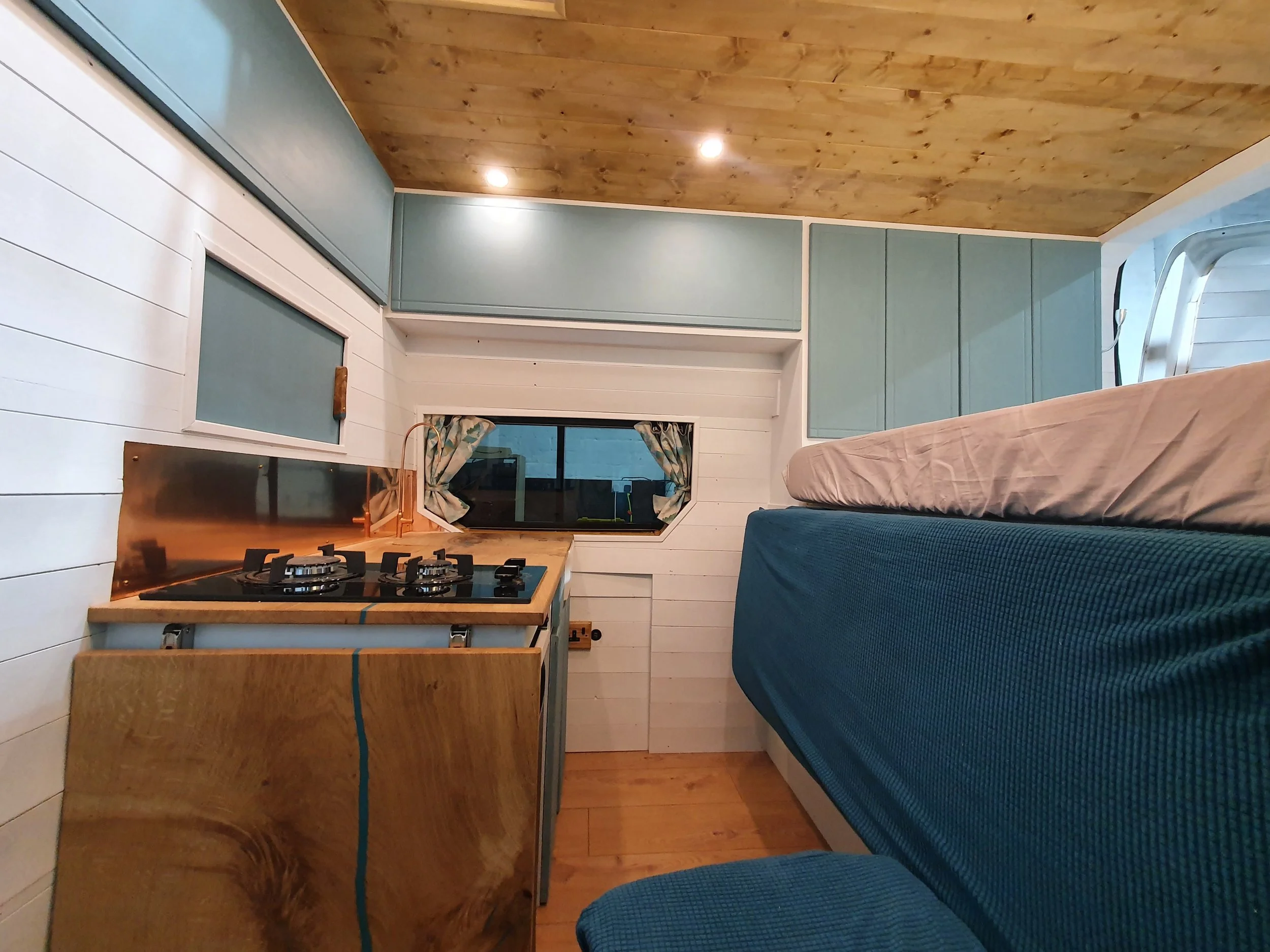 High-roof Vauxhall Vivaro. Semi-fixed bed, Garage space, Heated drying room, Pull out rails, Copper tap, Epoxy poured oak worksurface, Butlers sink, 2 ring hob. Photo 9 of 9.