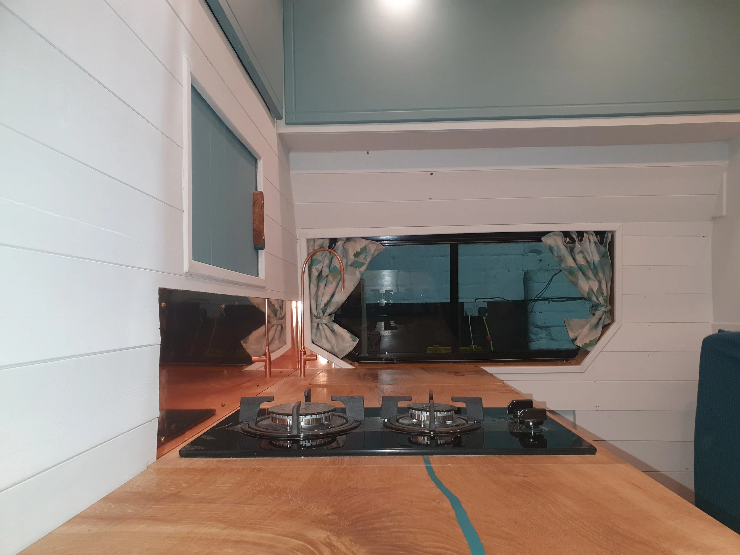 High-roof Vauxhall Vivaro. Semi-fixed bed, Garage space, Heated drying room, Pull out rails, Copper tap, Epoxy poured oak worksurface, Butlers sink, 2 ring hob. Photo 2 of 9.