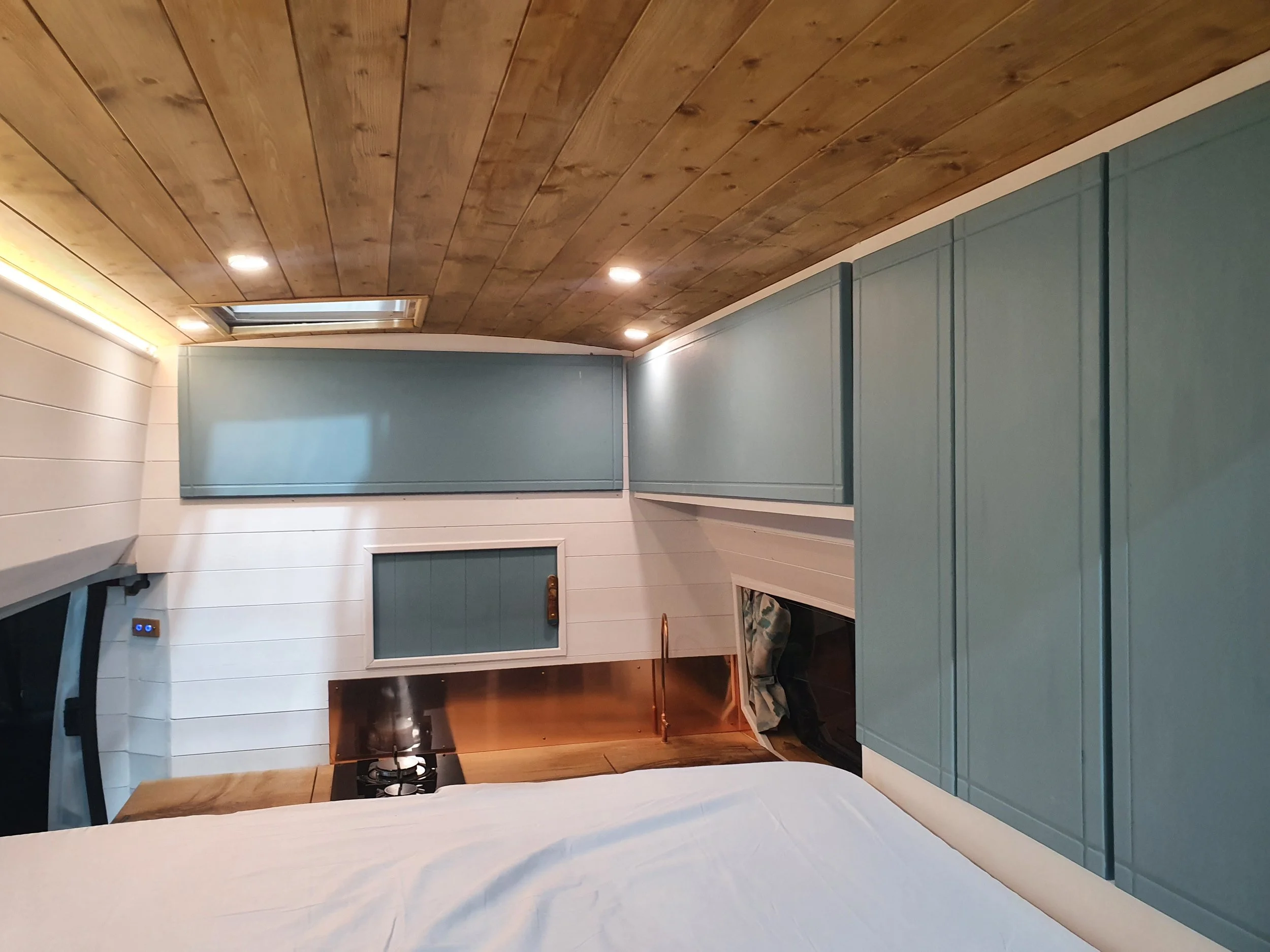 High-roof Vauxhall Vivaro. Semi-fixed bed, Garage space, Heated drying room, Pull out rails, Copper tap, Epoxy poured oak worksurface, Butlers sink, 2 ring hob. Photo 6 of 9.