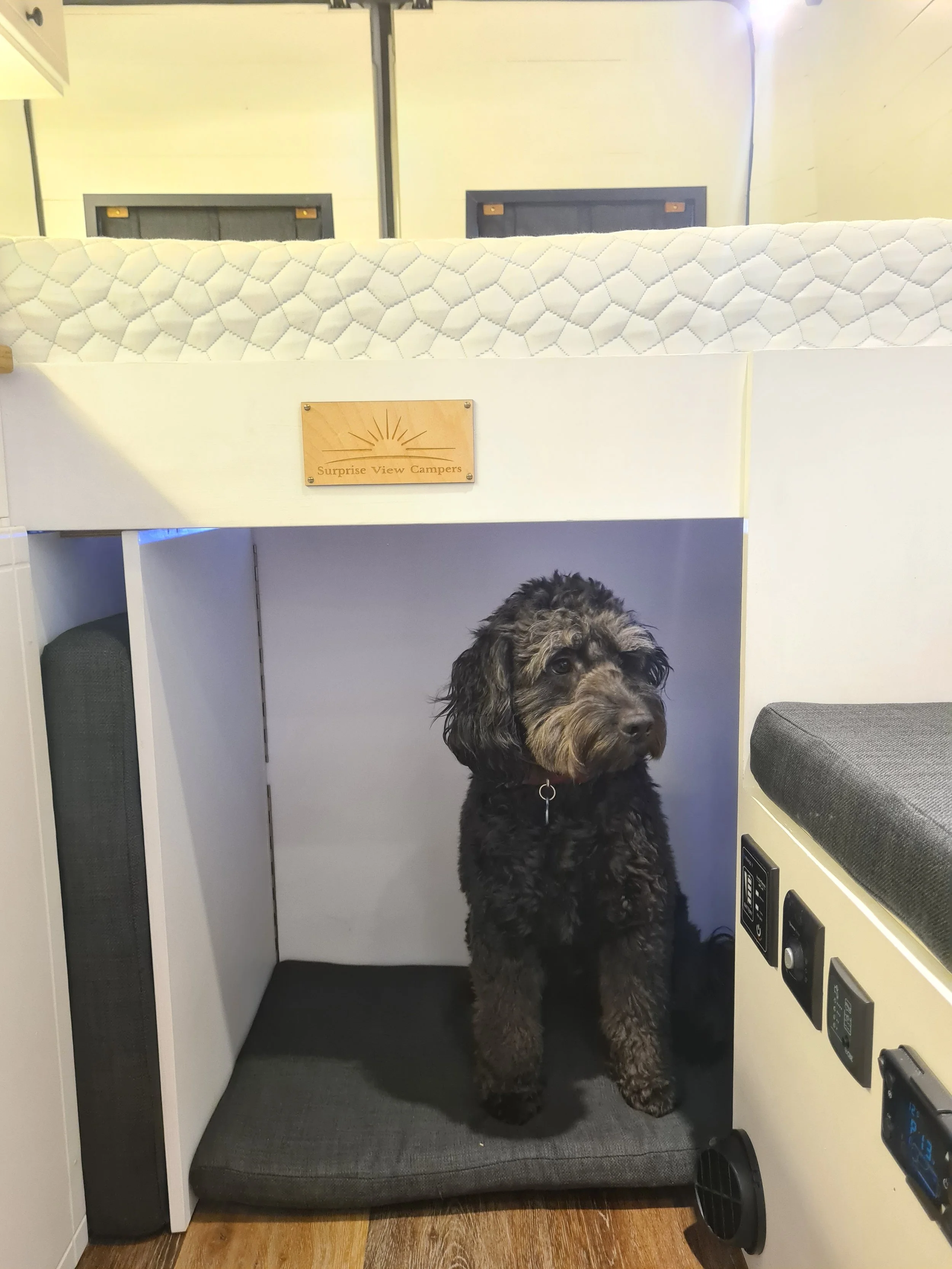 A camper interior with a place for a dog under the seating.